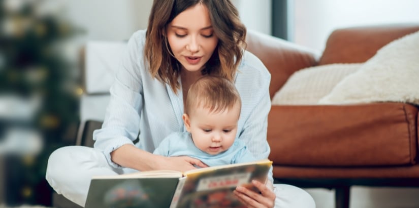 Une maman qui montre un livre à son bébé