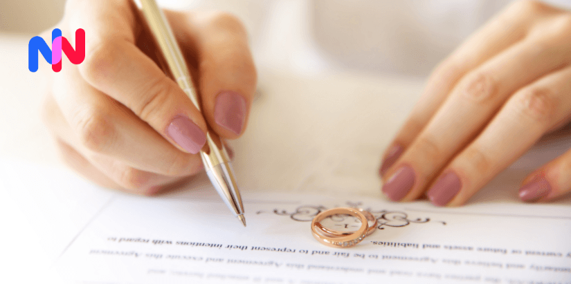 Une personne signant un contrat de mariage avec deux bagues sur le papier
