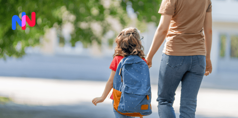 Une enfant qui va à l'école avec un de ses parents